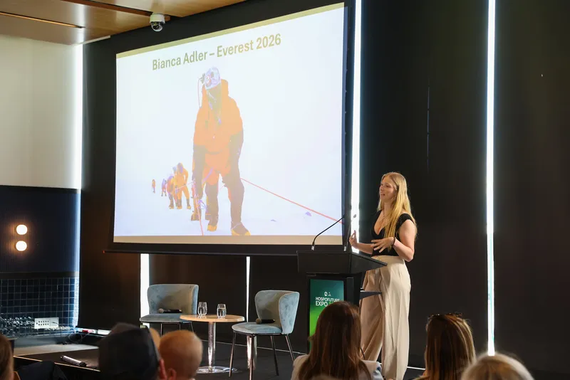 Bianca giving a keynote, with her Everest summit photo on the screen behind her