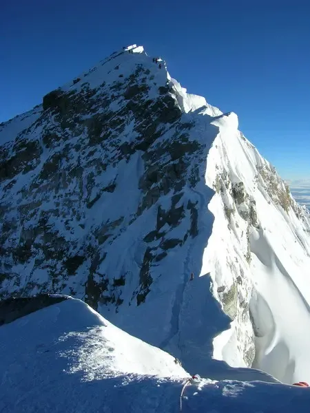 The summit ridge of Mt Everest against a deep blue sky